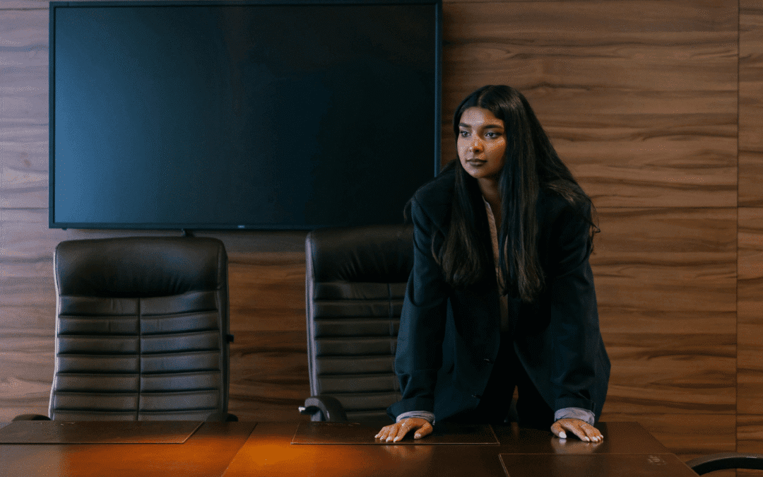 Strong, pensive leader leaning on desk in office setting
